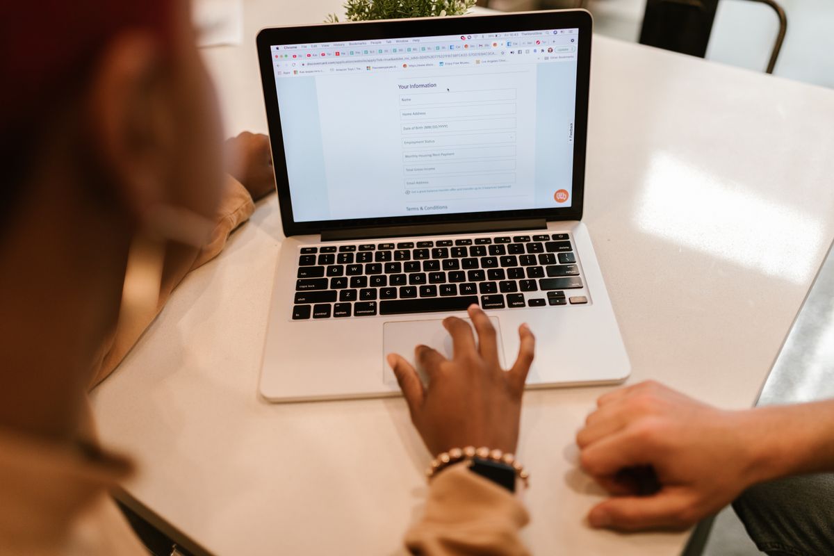 Hands on a laptop completing an online form