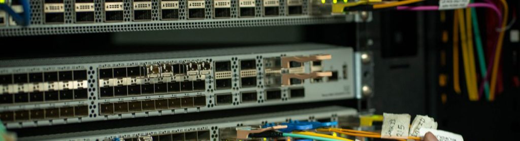 Hands cabling a network switch in a server rack