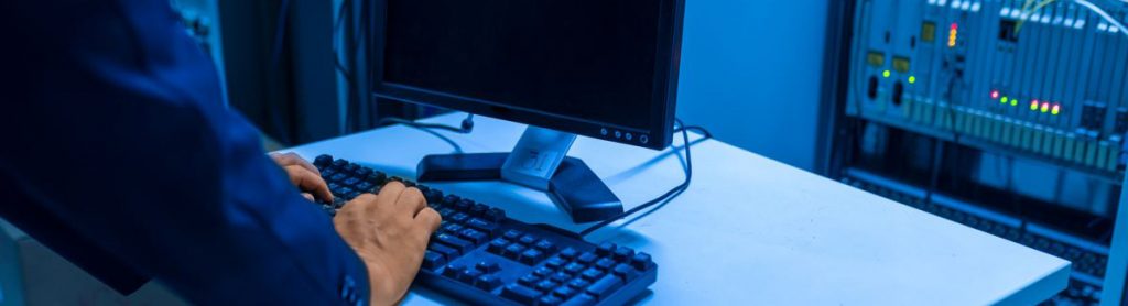 Technician working at a computer in a server room