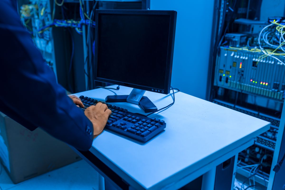 Technician working at a computer in a server room